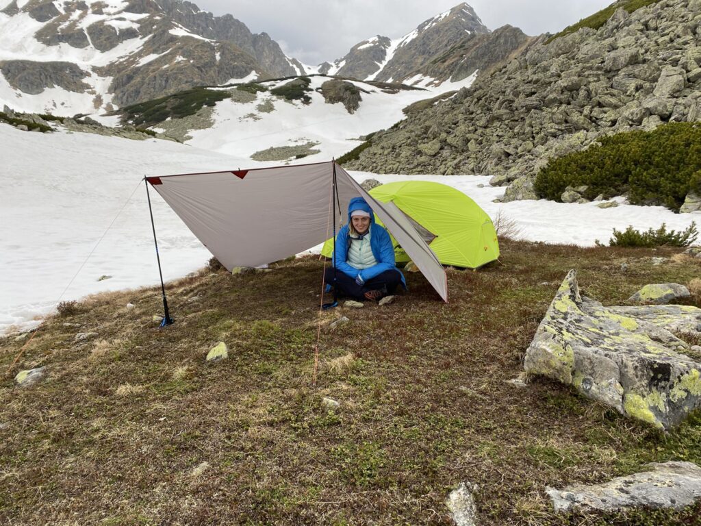 Tarp und grünes Zelt in alpiner Landschaft ohne erkennbare Gesichter