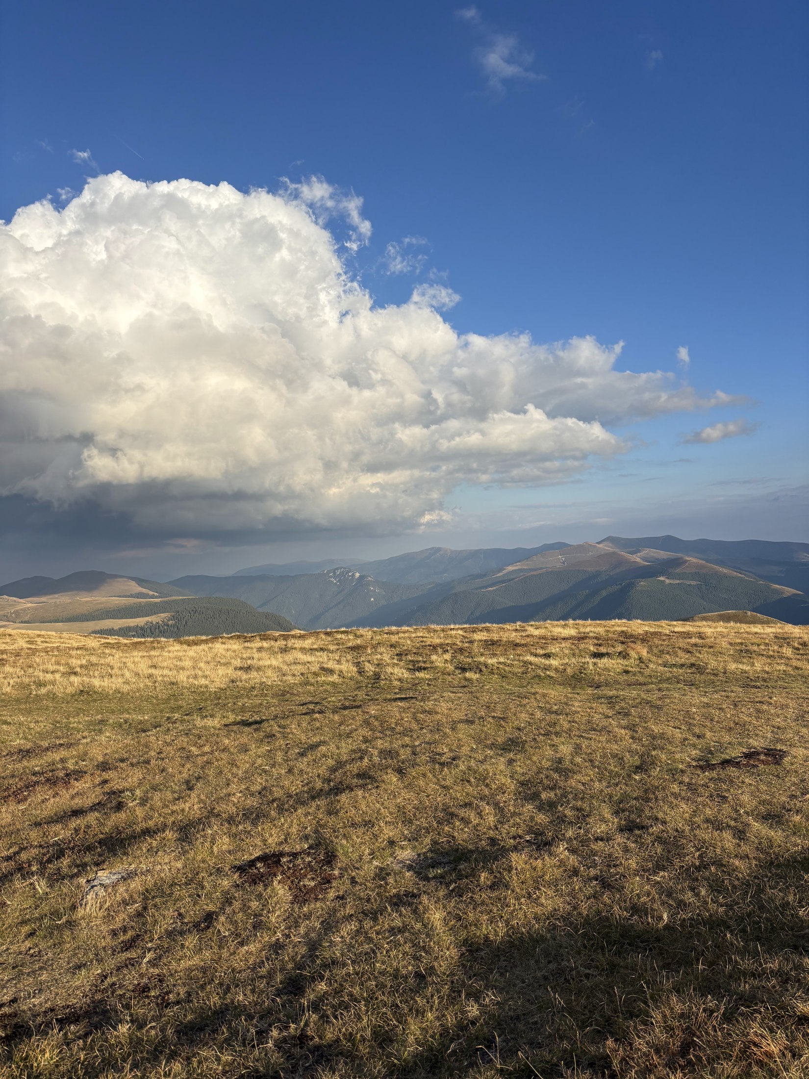 Weite goldene Bergkämme der Strategica unter dramatischen Wolken.